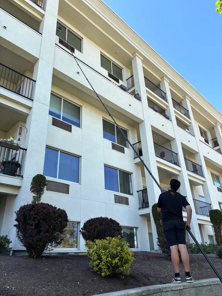 Beam's technician using a water-fed pole on a strata building