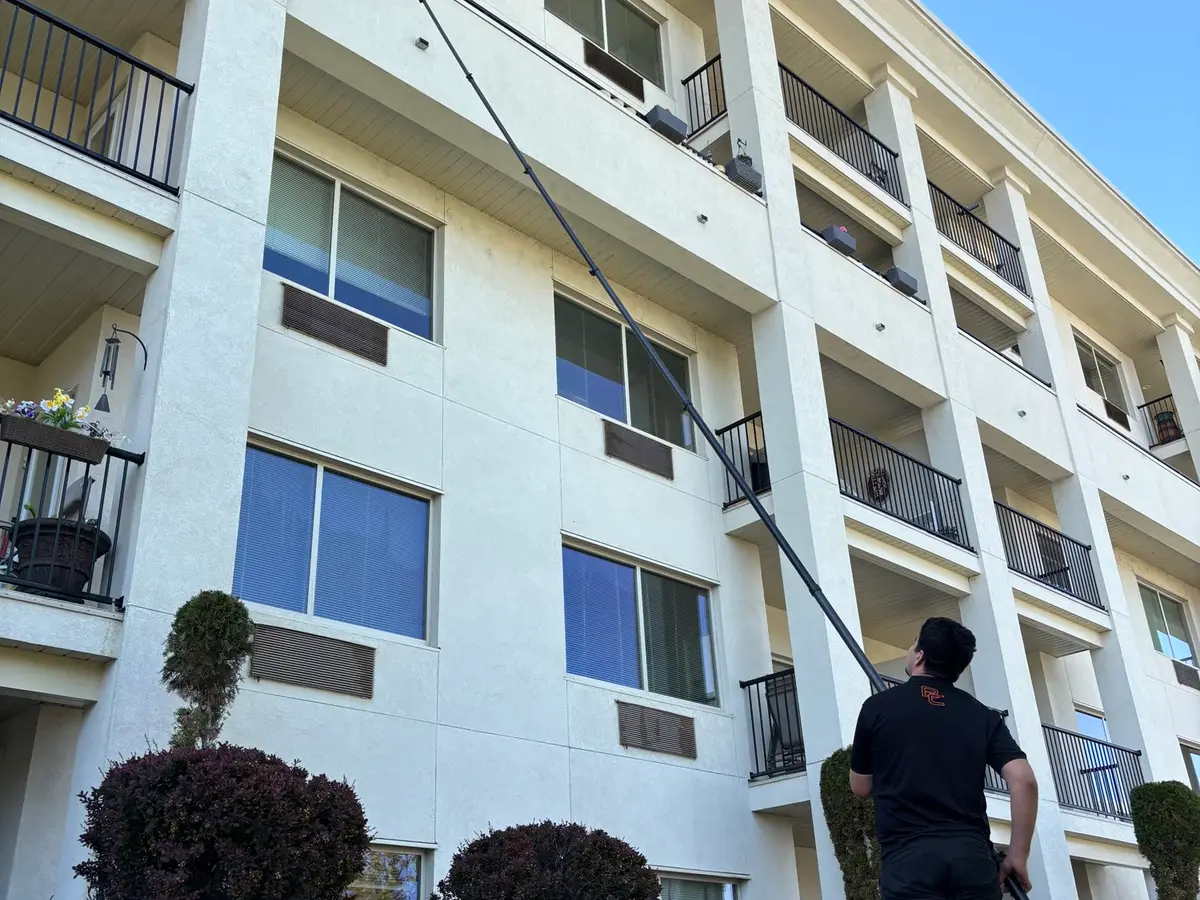 Beam's technician using a water-fed pole on a strata building