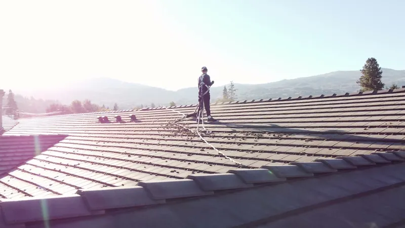 Beam’s technician wearing fall protection while working on a tiled roof