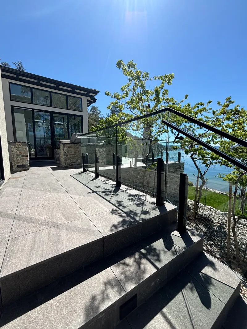 Lakeside stone patio, steps and glass railings